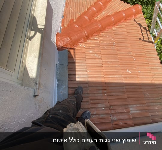 גג רעפים עם צינורות כתומים ועובד על הגג